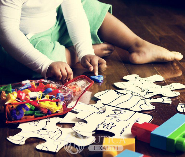 african-descent-kid-enjoying-puzzles-on-wooden-PRFCBQP-768x654